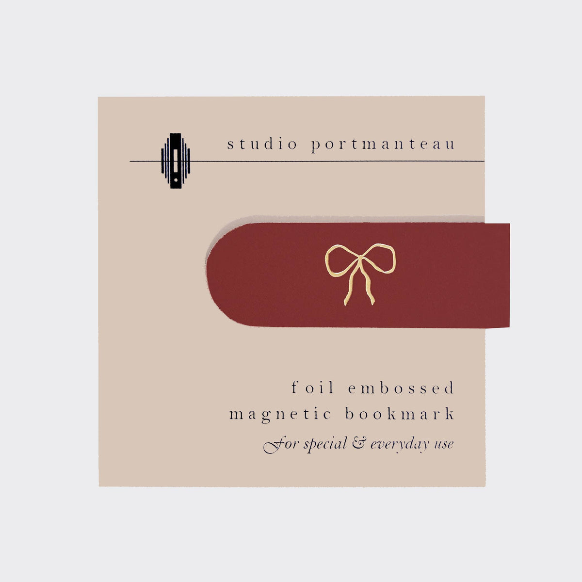Foil embossed magnetic bookmark with bow design on a beige card from Studio Portmanteau.