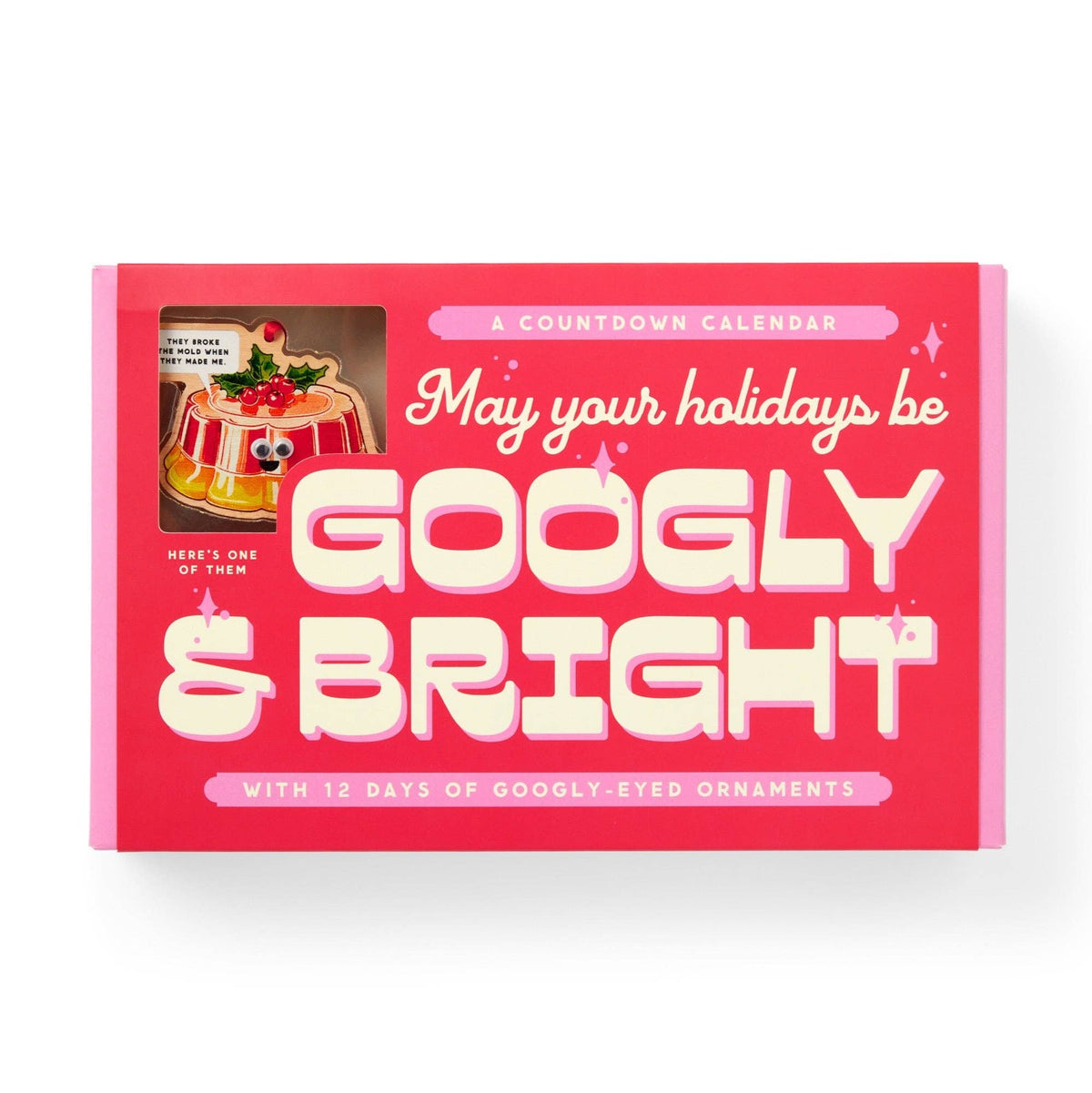 A pink boxed holiday countdown calendar with large cream text reading 'May your holidays be GOOGLY & BRIGHT' and a small window showing a decorated pudding ornament. The box is photographed on a clean white background.