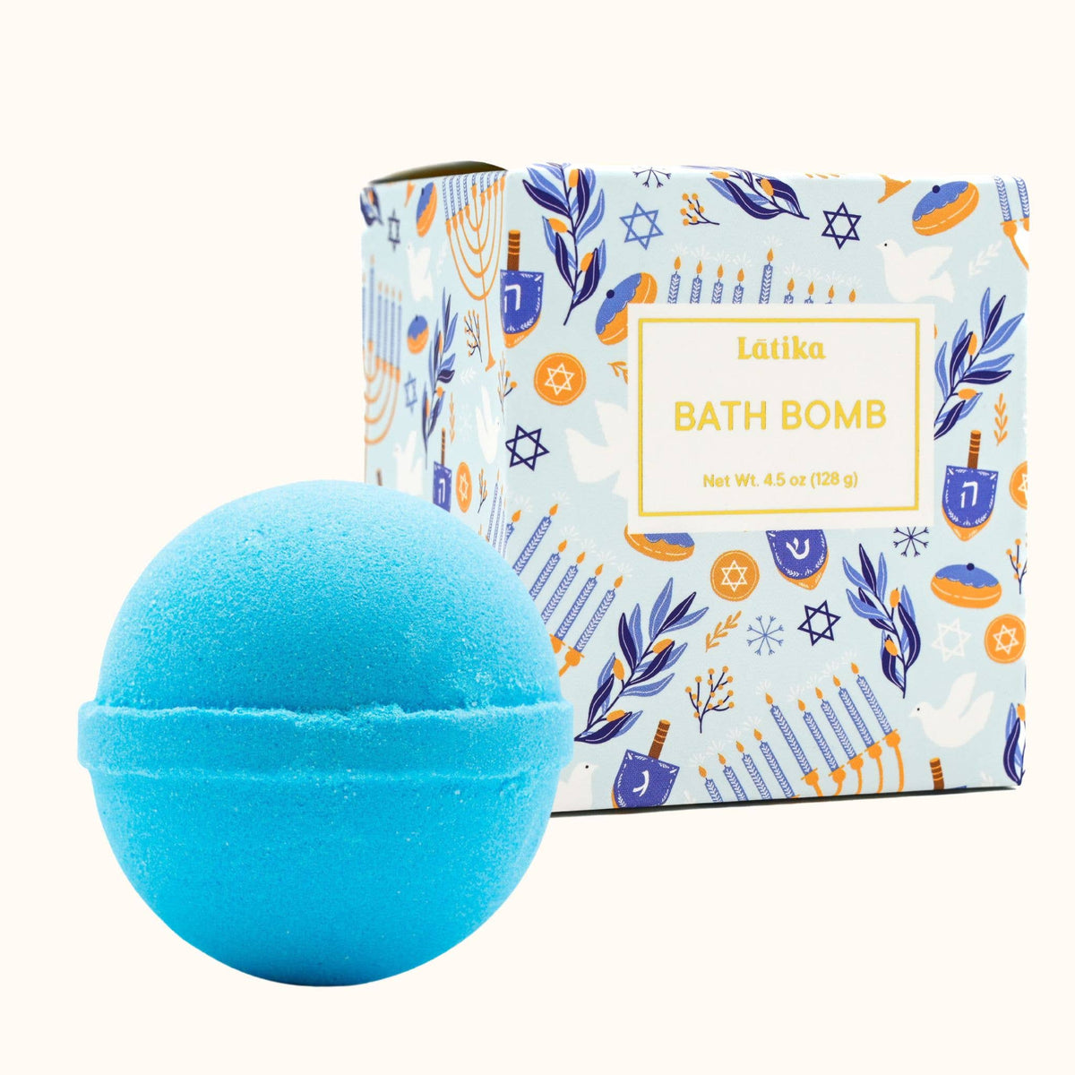 A bright blue bath bomb in the foreground with its illustrated product box behind it on a light cream background. The box reads 'Latika BATH BOMB' and has a festive multicolor pattern.