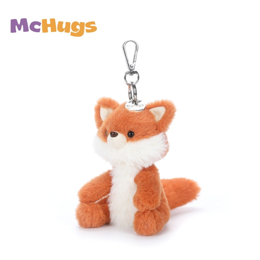 A plush fox keychain from McHugs, featuring orange and white faux fur with a silver metal clasp at the top, shown on a plain white background.