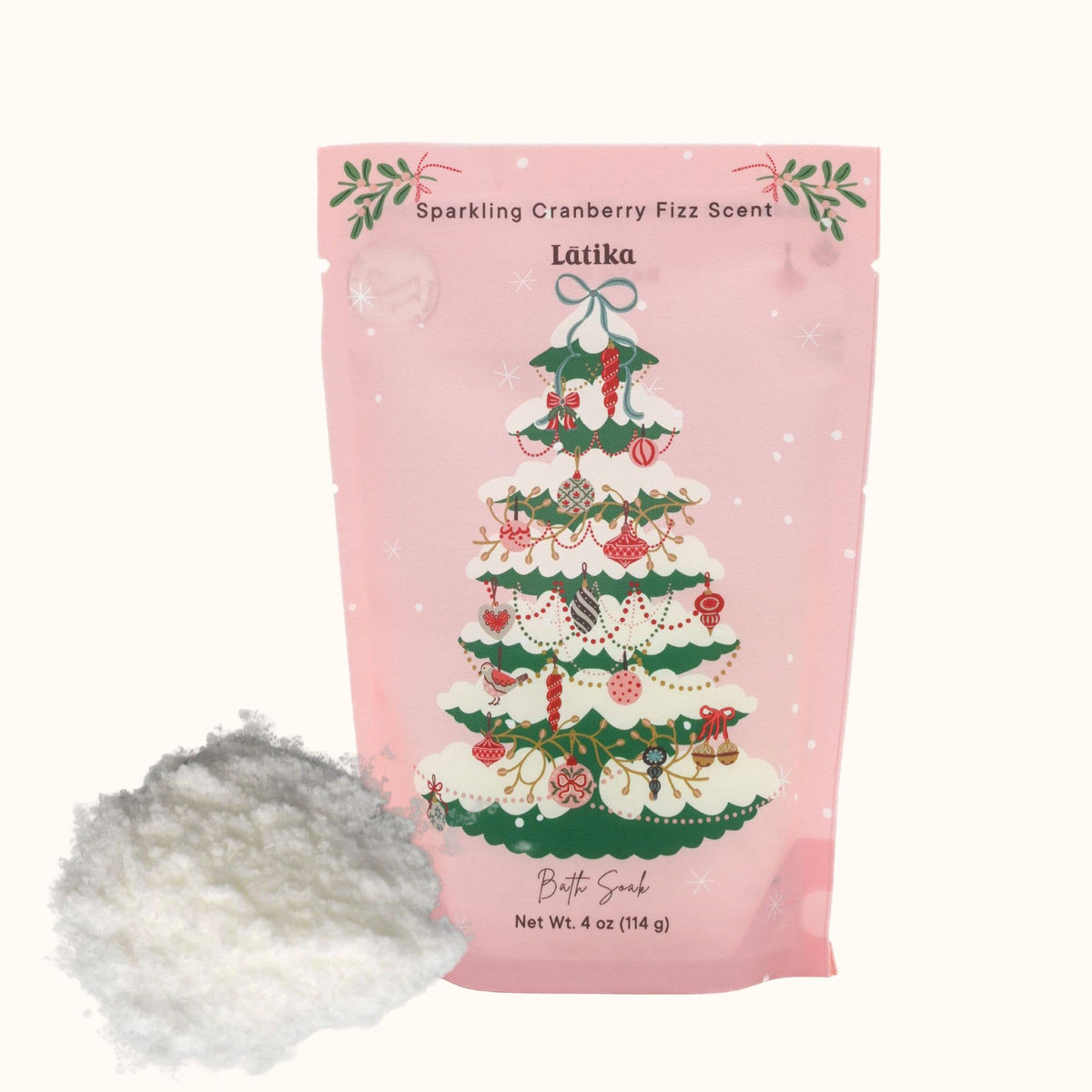 A pink stand-up pouch labeled 'Sparkling Cranberry Fizz Scent' by Latika, featuring a decorated Christmas tree illustration, with a small pile of white fizzing powder shown in front on a light beige background.