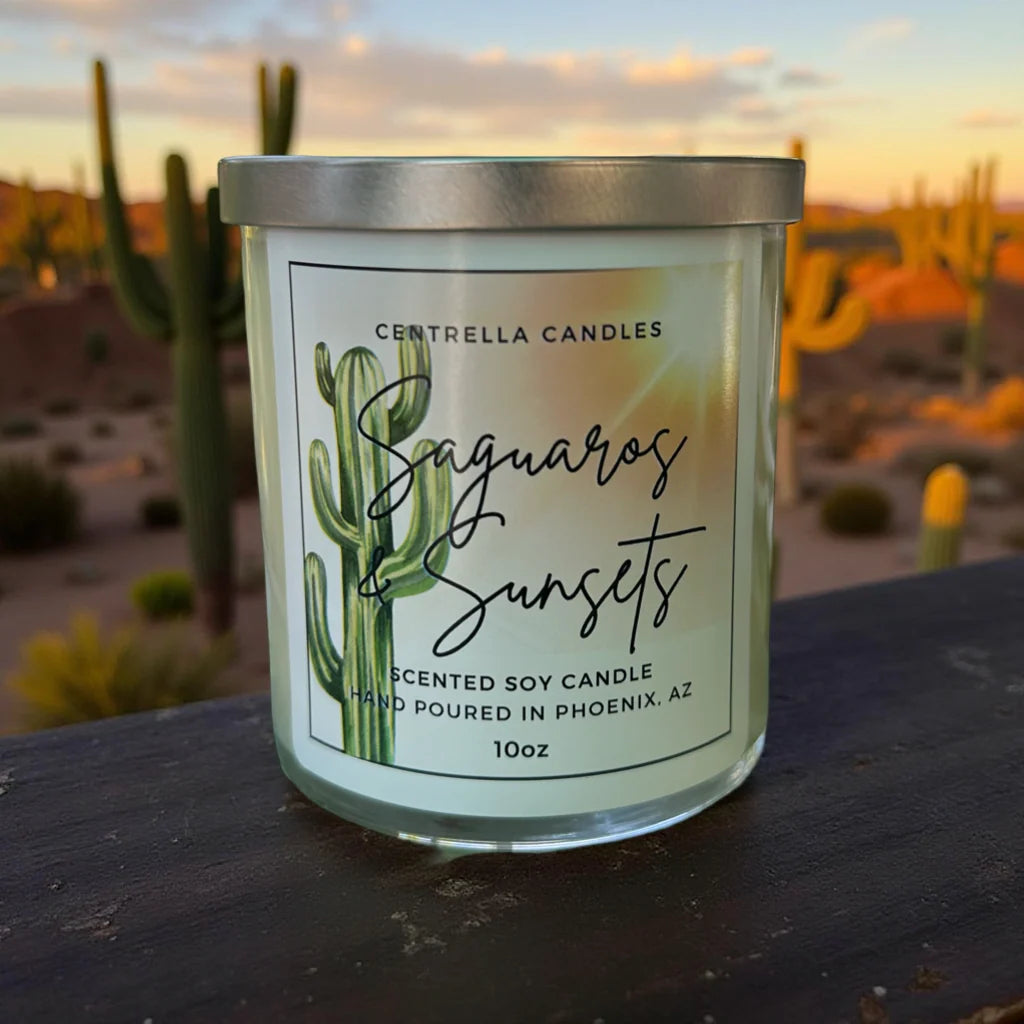 A 10oz scented soy candle by Centrella Candles named 'Saguaro & Sunsets', in a clear glass jar with a silver lid and a white label featuring a green saguaro cactus illustration. 
