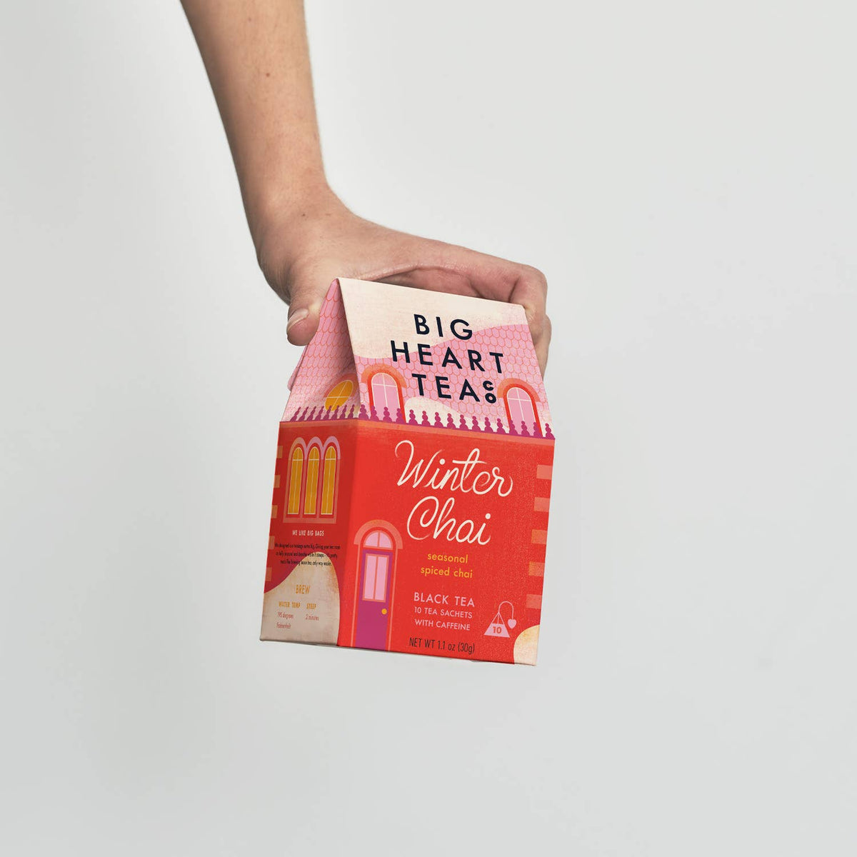 Person holding a box of Big Heart Teas Winter Chai tea against a plain background